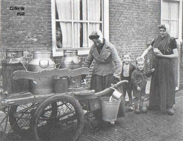 Het dagelijks leven herneemt z'n gewone gang. Marie Koster gaat elke dag met haar melkkarretje door Arnemuiden. Hier giet ze een liter melk in de emmer voor Dora Meulmeester-van Dalen met twee van haar kinderen.