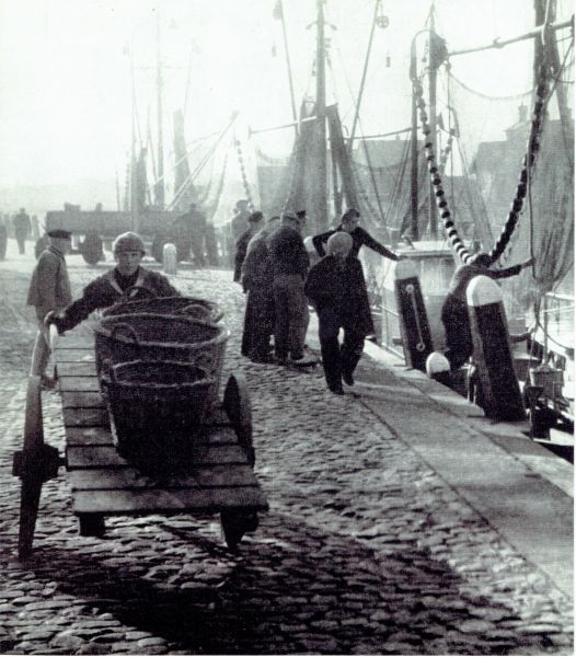 Bedrijvigheid in de haven van Veere. De vangst wordt op een kar naar de vis-mijn gebracht.