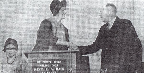 Mevrouw Hack feliciteert de voorzitter van het stichtingsbestuur ds. G.S. Oegema met het leggen van de eerste steen voor het bejaardencentrum Te Mortiere. Links mevrouw Oegema.