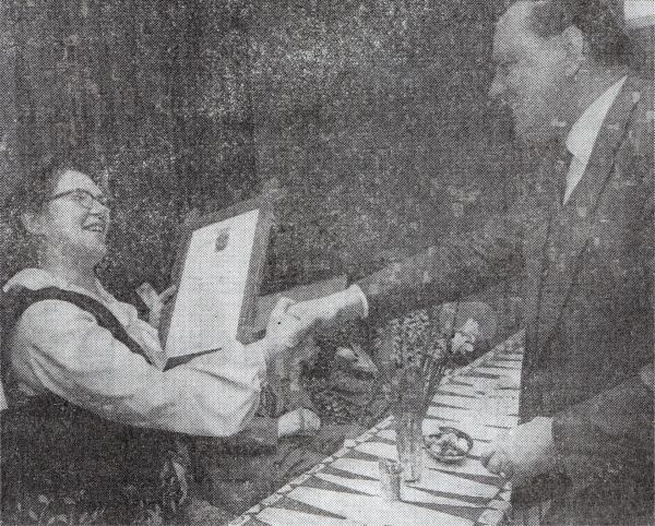 Burgemeester J. de Jonge overhandigt de oorkonde en de zilveren legpenning aan wijkzuster N. van Donk, die bij haar afscheid ereburgeres van Arnemuiden wordt.