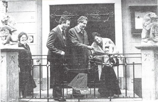 Commissaris van de Koningin dr. C. Boertien pakt de sleutel van het kussen, dat de 4-jarige Marie-Jeanne de Vos voor hem ophoudt. Links mevrouw Markusse en rechts mevrouw Boertien.