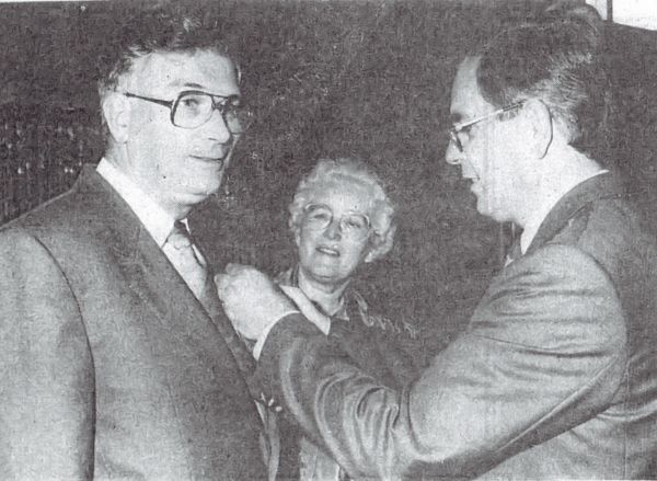 Burgemeester Markusse speldt de scheidende gemeentesecretaris en ereburger van Arnemuiden J. Kroon de koninklijke onderscheiding op.